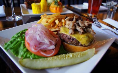 Half-pound beef burger made from 100% natural ground chuck served with crisp lettuce, sliced tomato, and red onion on a toasted soft roll