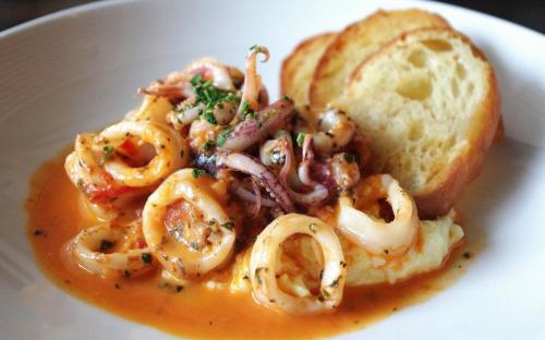 Tender calamari served over creamy rosemary-scented polenta, smoked mozzarella, Italian plum tomatoes, and fresh herbs