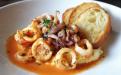 Tender calamari served over creamy rosemary-scented polenta, smoked mozzarella, Italian plum tomatoes, and fresh herbs